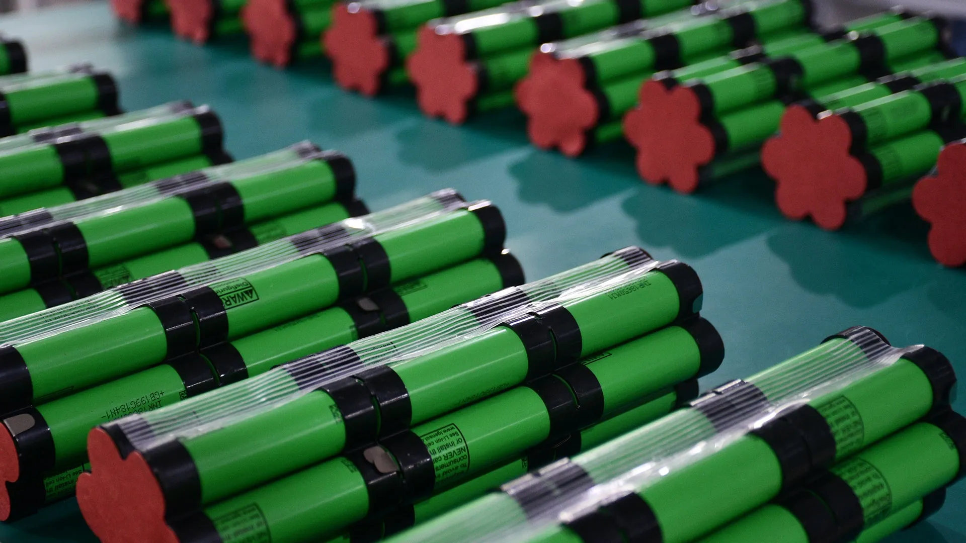 Green cylindrical lithium cells grouped into battery modules during pack build