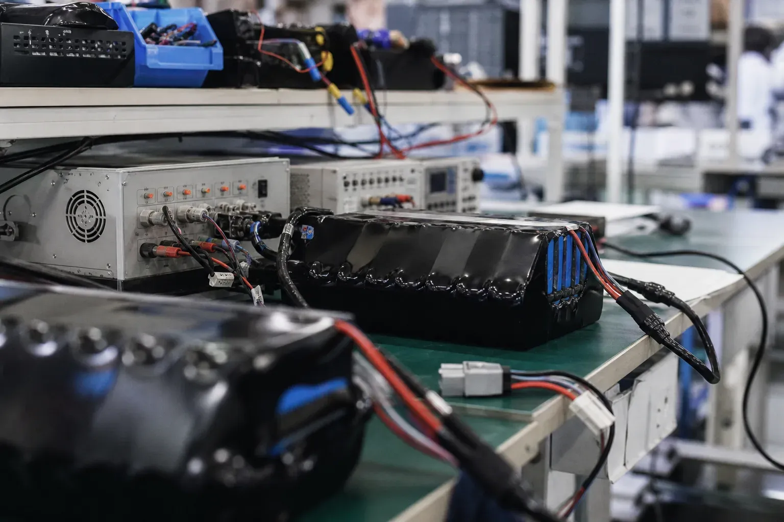 Battery packs connected to lab test equipment on a workbench